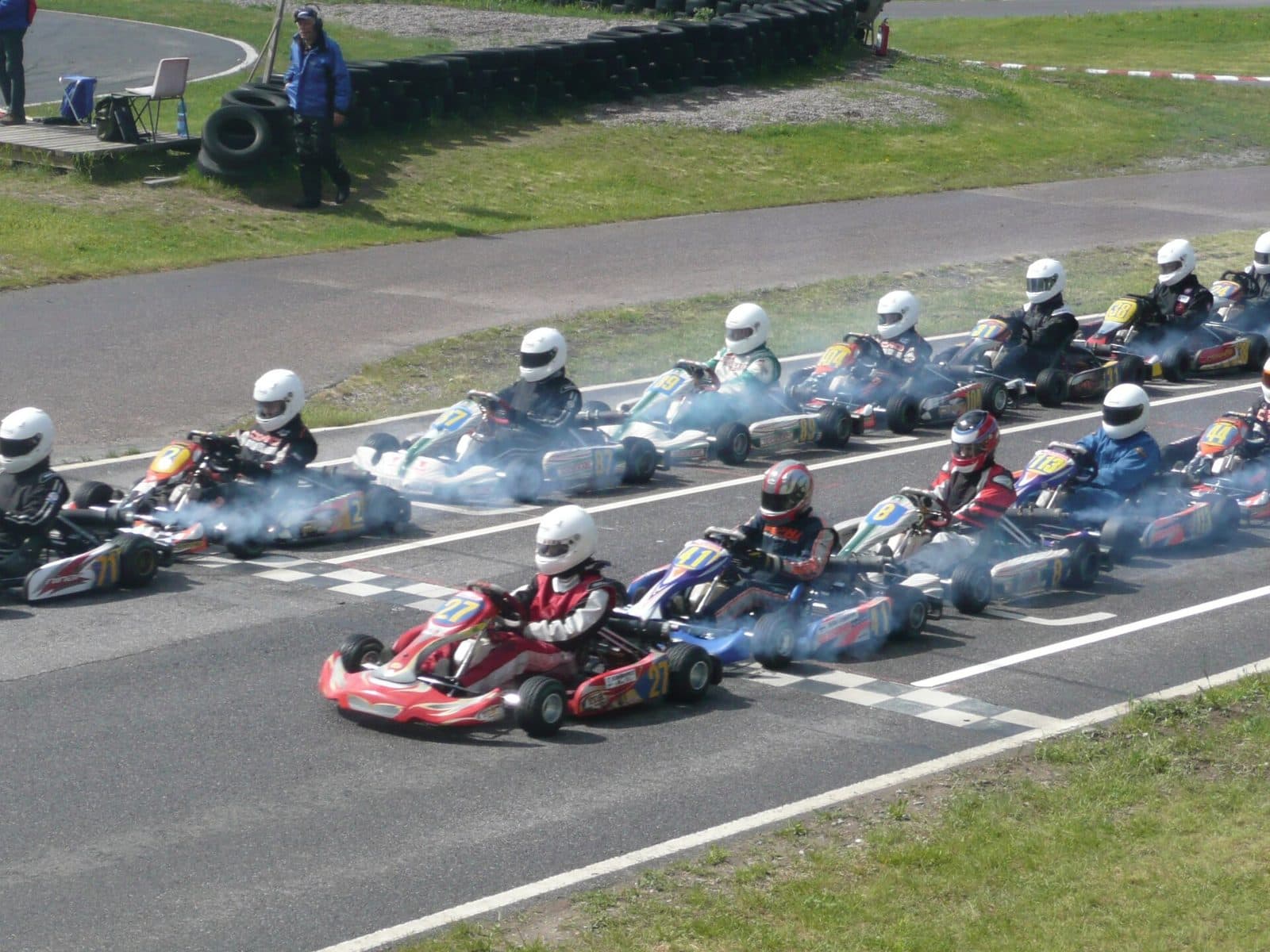 A pack of karts racing into the first corner after the start