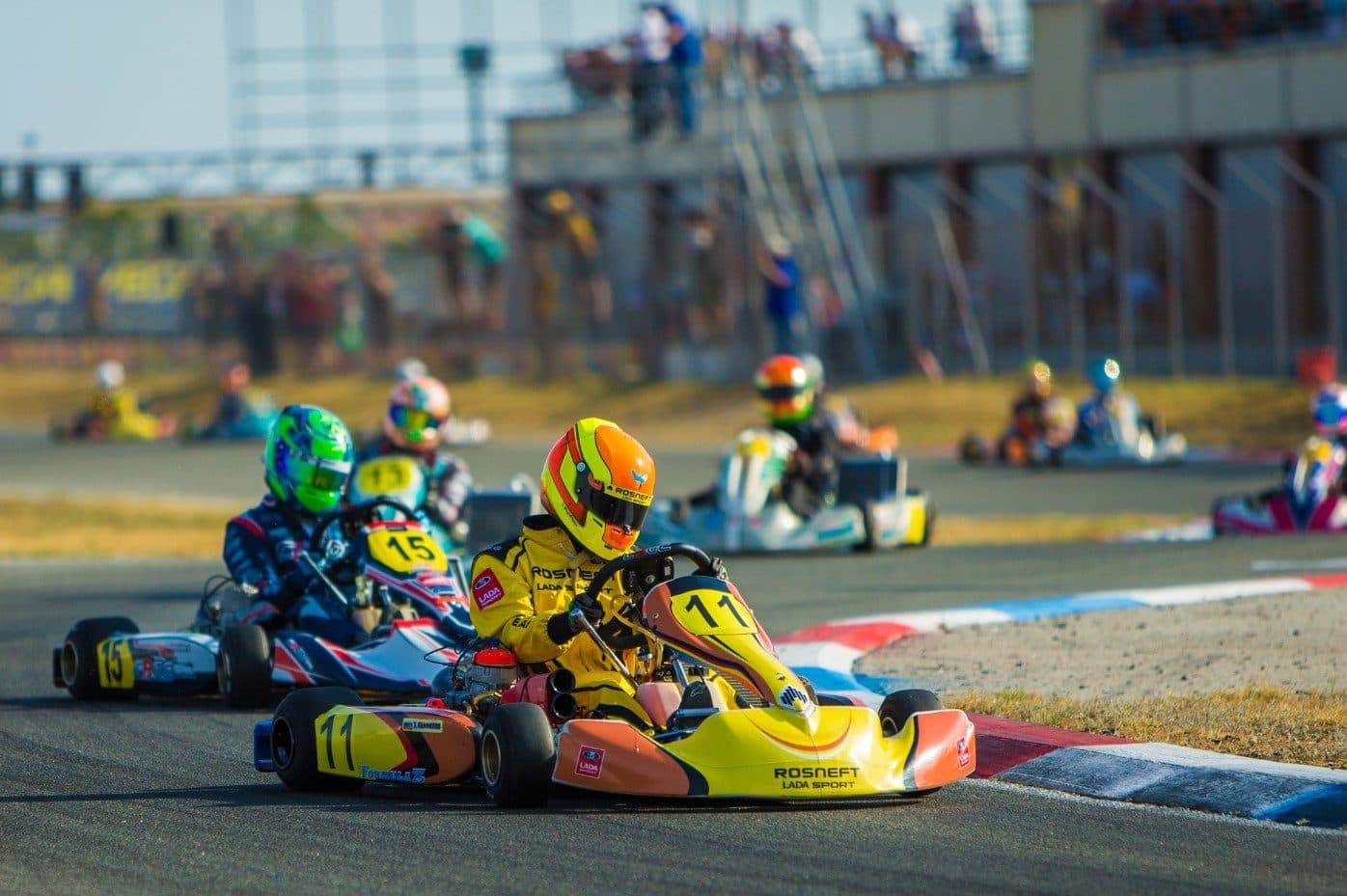 A KZ2 kart turning in at an apex kerb with other karts behind