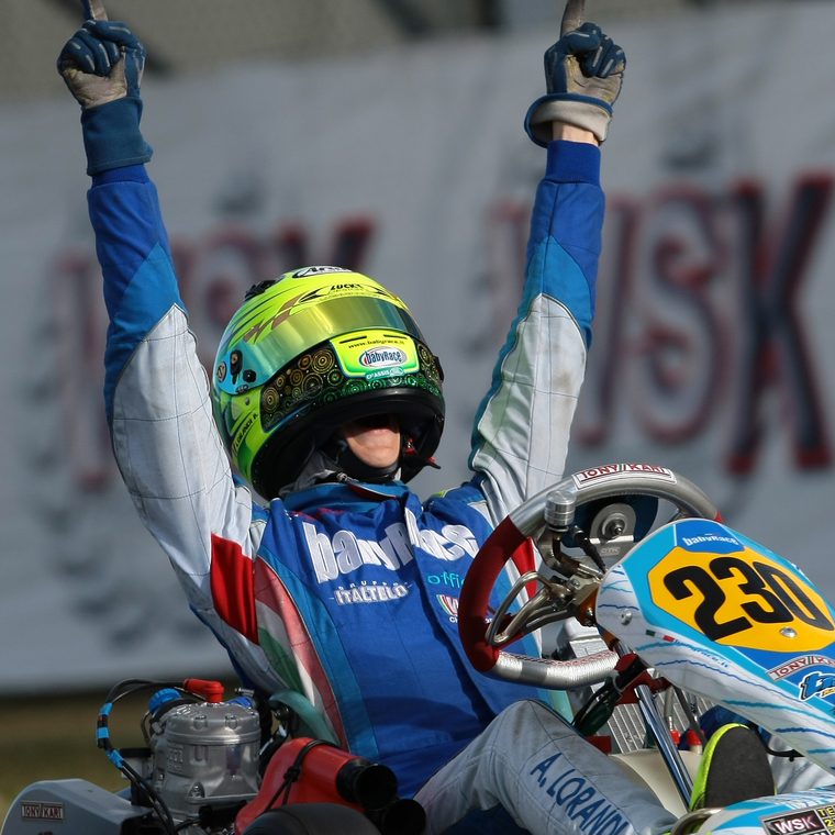Alessio Lorandi crossing the line with both arms raised, winning in the kart